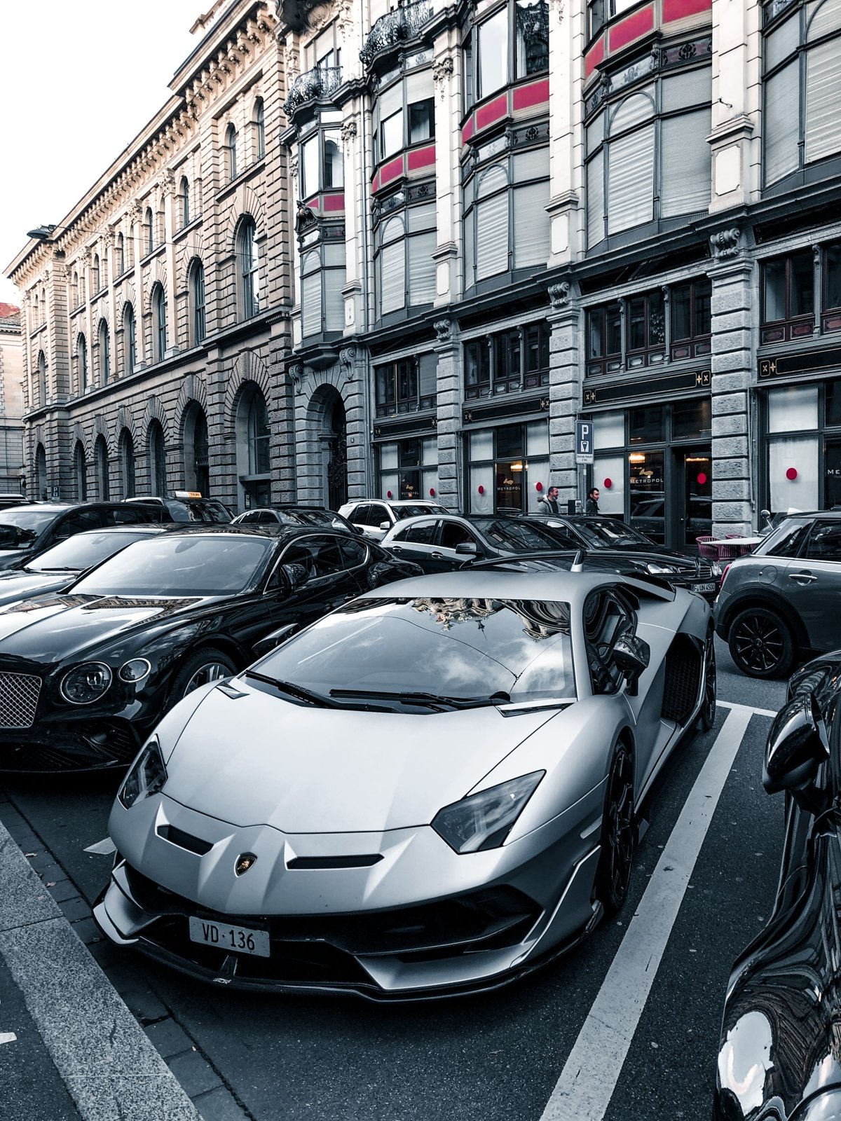 A collection of luxury and exotic cars on a city street