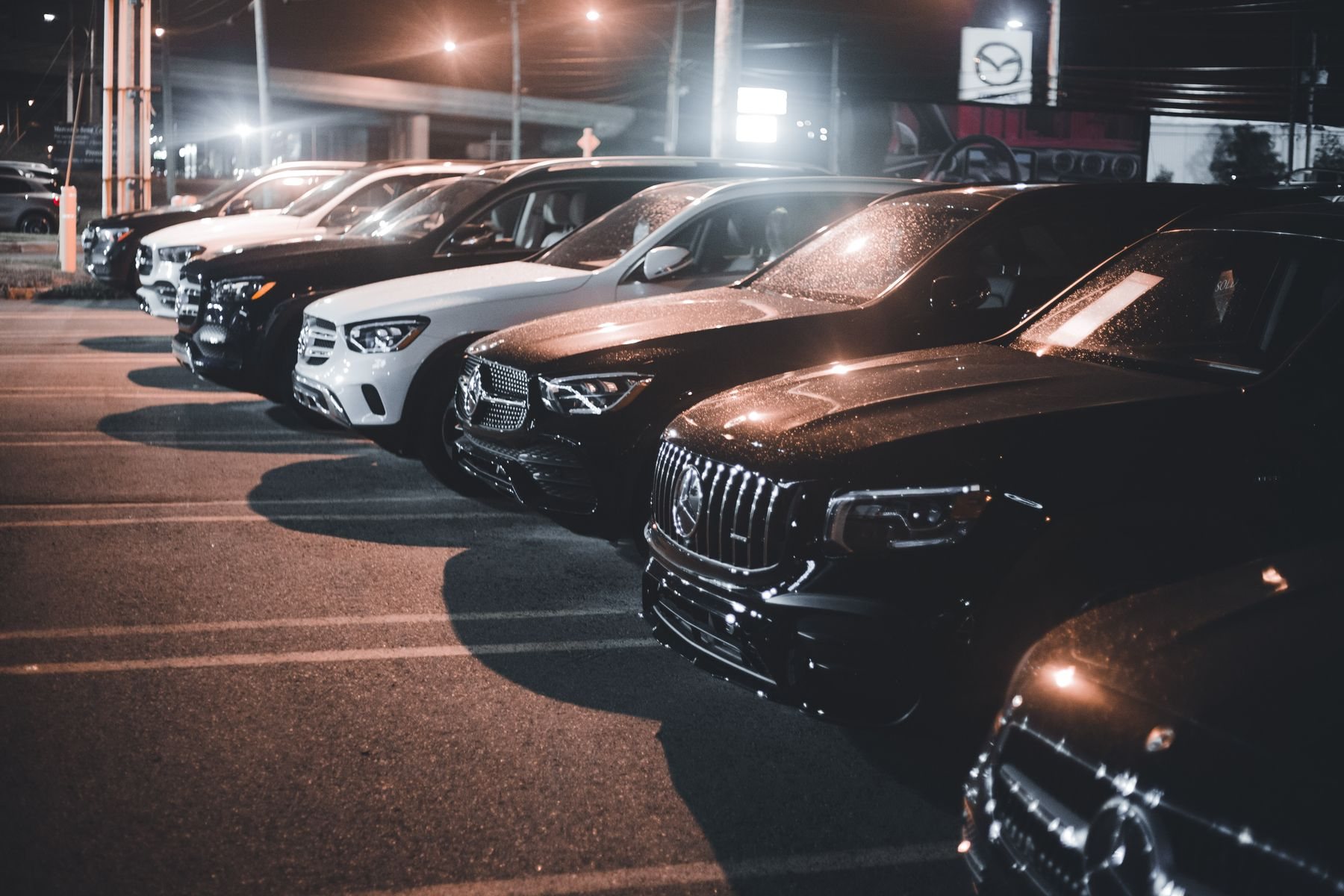 A row of luxury vehicles in an evening setting