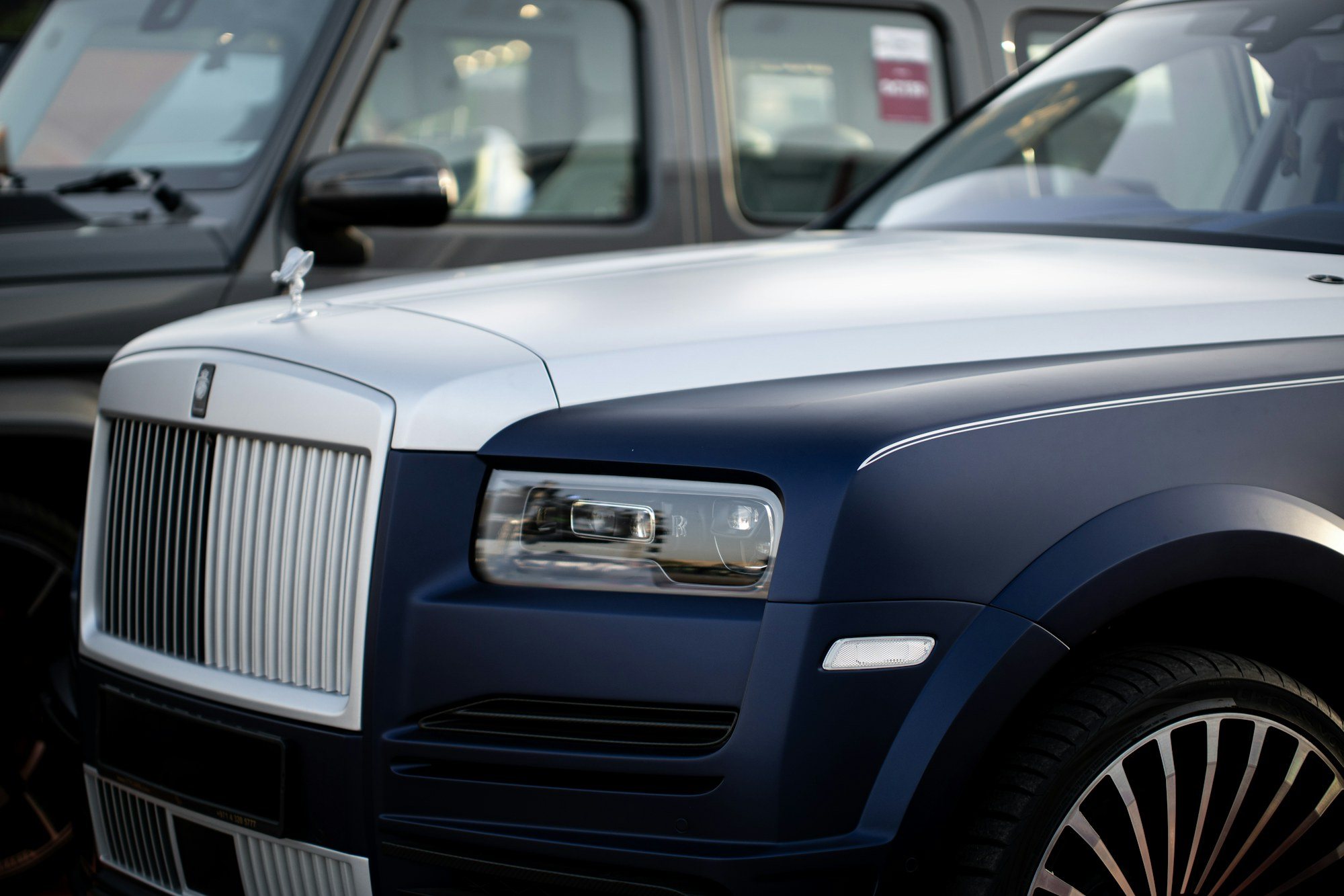 A Rolls-Royce Cullinan and a Mercedes G-Class parked together